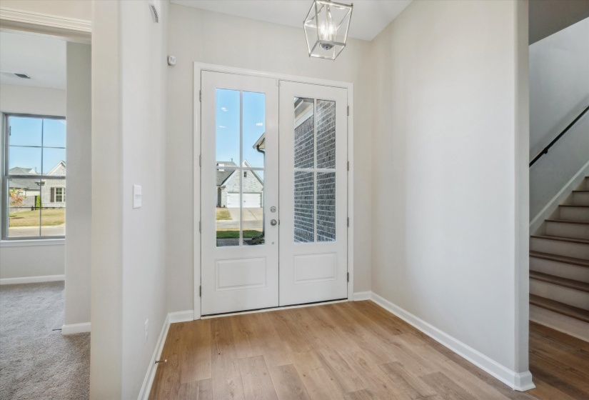 Foyer entrance with light wood-style flooring and french doors