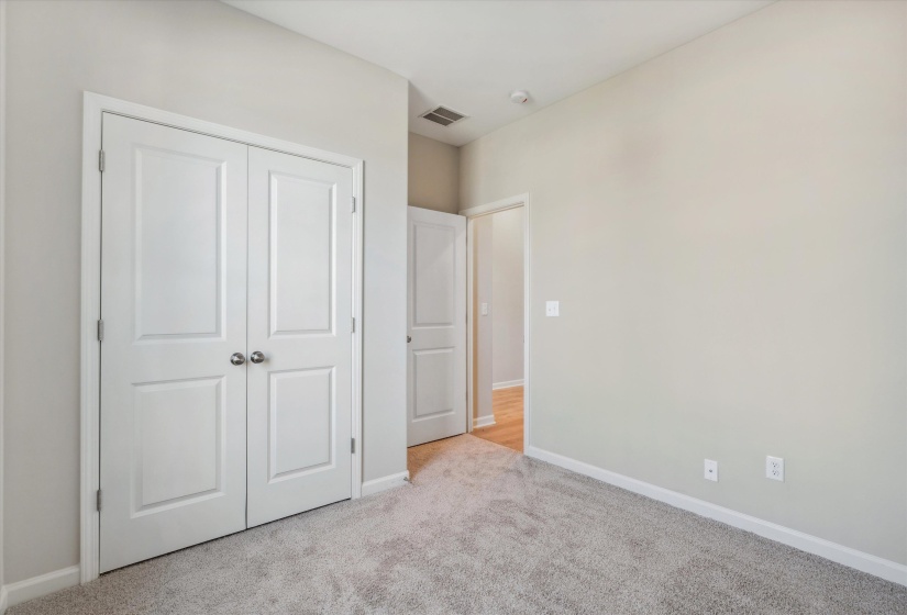 Unfurnished bedroom featuring light carpet and a closet