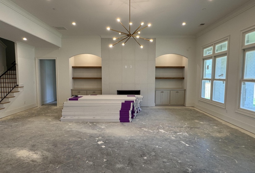 Spacious living area featuring a modern chandelier, recessed lighting, and large windows
