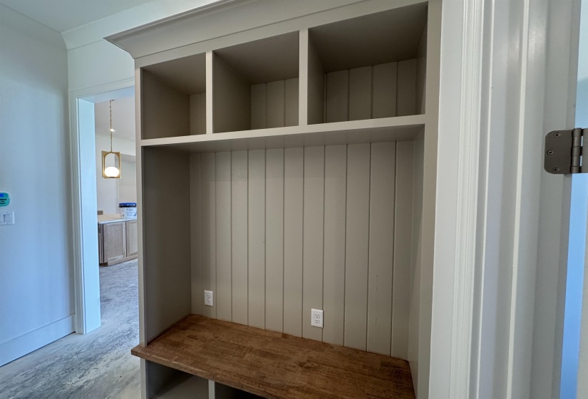 Built-in mudroom bench with wood-finish seating, beadboard backing, and integrated cubby storage