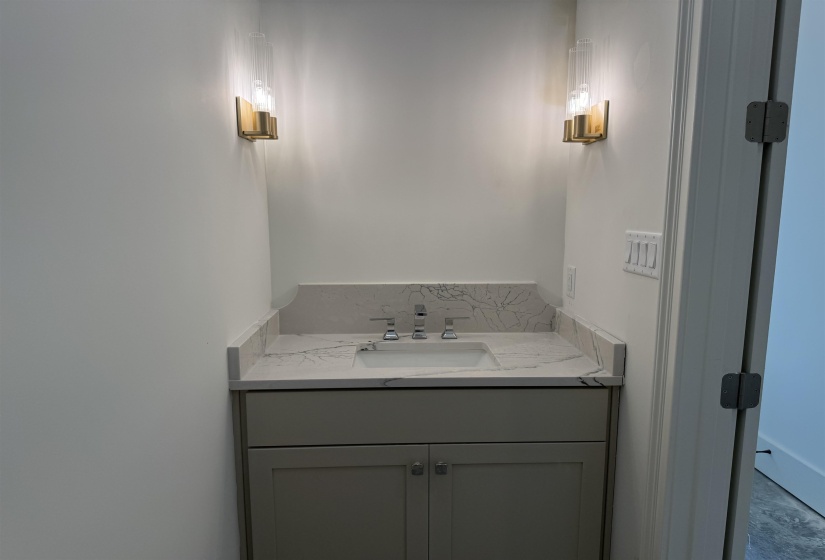 Vanity with a white countertop and integrated sink, gray cabinetry, and brushed nickel hardware