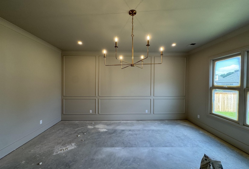 Room featuring decorative wall paneling, a bronze-finish chandelier, recessed lighting, and crown molding