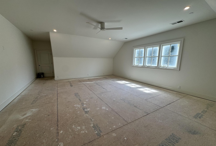 Spacious room featuring a multi-paned window, recessed lighting, and a ceiling fan