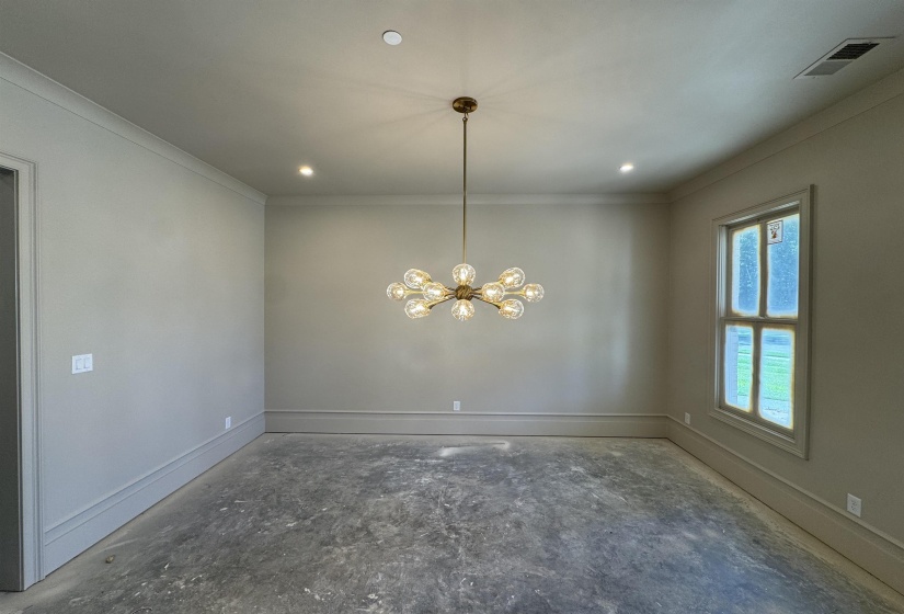 Spacious interior featuring a modern chandelier, recessed lighting, crown molding, and baseboard trim