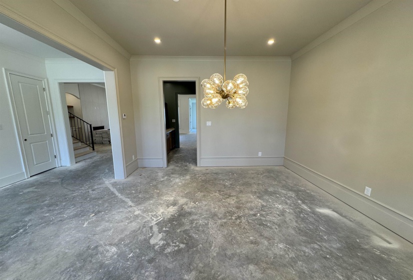 Open room featuring a contemporary chandelier, recessed lighting, crown molding, and substantial baseboards