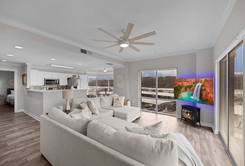 Living area featuring ornamental molding, ceiling fan, and light wood-style flooring