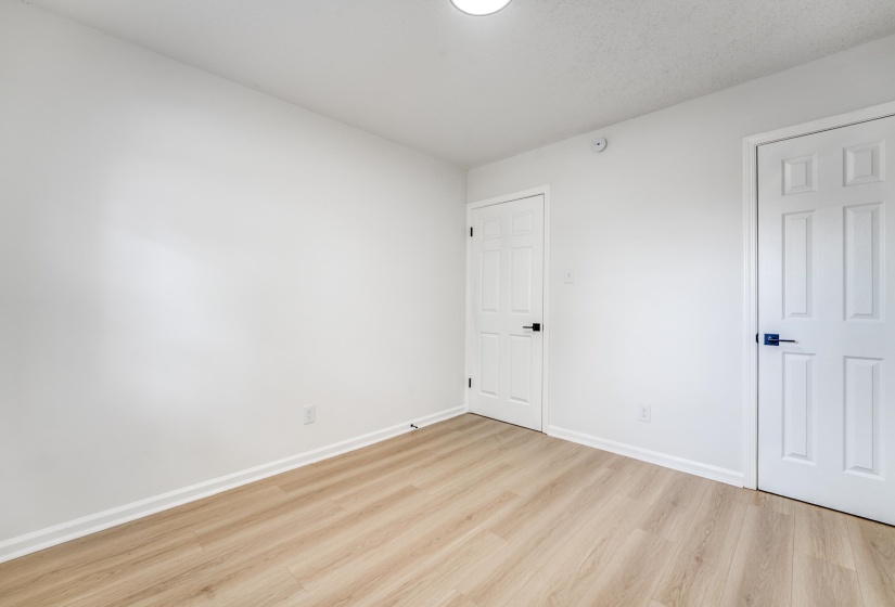 Unfurnished bedroom with light wood-style floors and baseboards