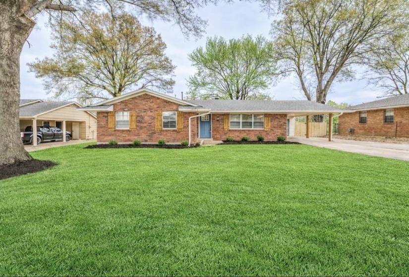 Ranch-style home featuring a carport, brick siding, a front lawn, and concrete driveway