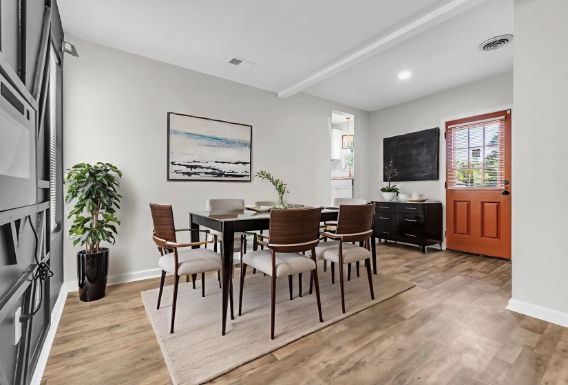 Dining room with beam ceiling and light wood-style flooring