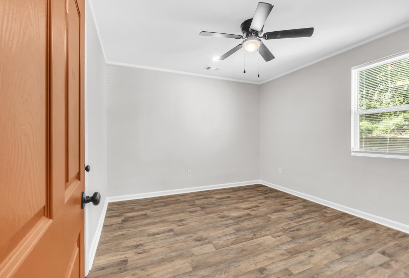 Spare room featuring wood finished floors, ornamental molding, and ceiling fan