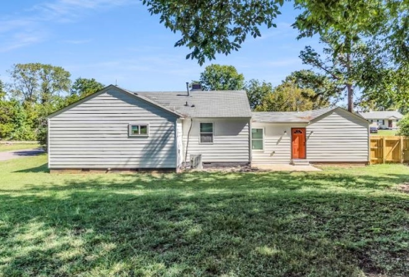 Rear view of property featuring a yard and crawl space