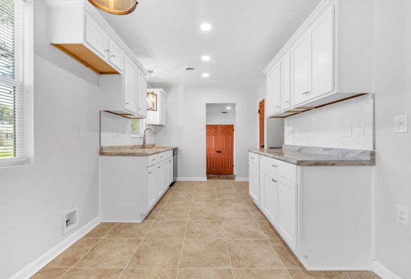 Kitchen featuring white cabinetry, light countertops, light tile patterned floors, recessed lighting, and decorative backsplash
