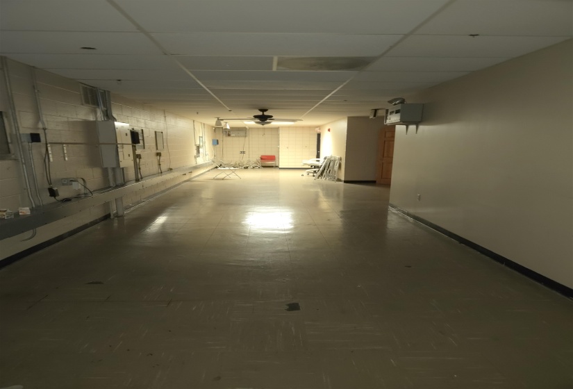 Garage with a ceiling fan and baseboards