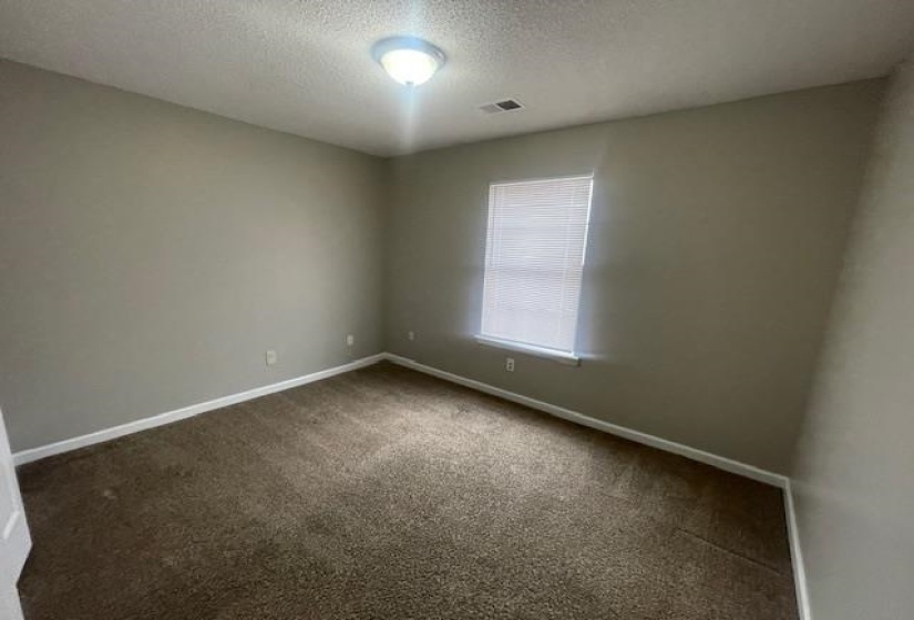 Carpeted spare room featuring baseboards and a textured ceiling