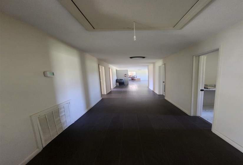 Hallway featuring attic access and baseboards