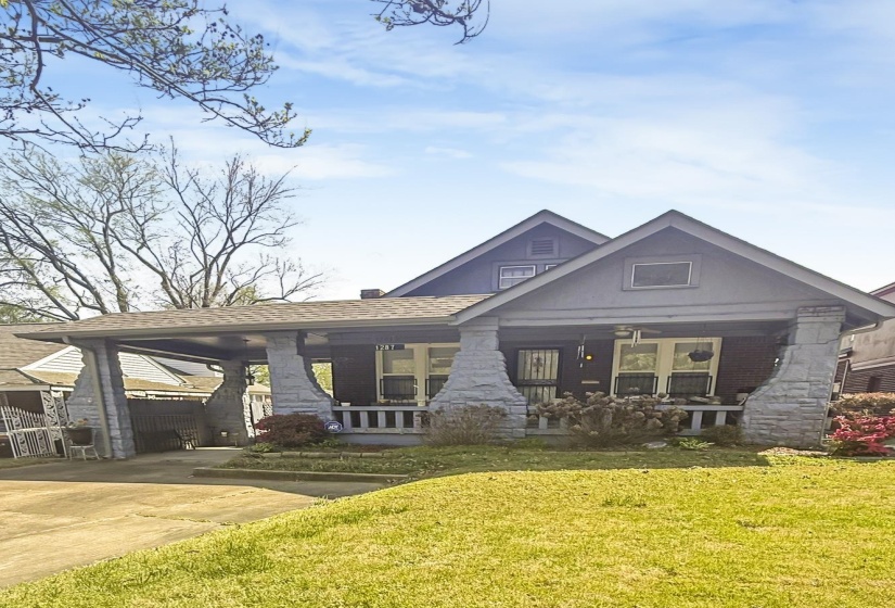 View of front of home with an attached carport, covered porch, and concrete driveway