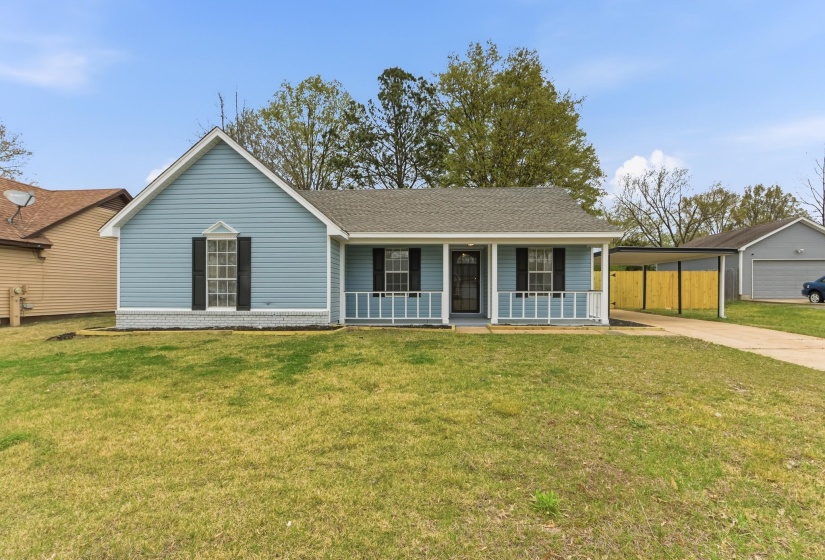 View of front of property featuring covered porch, roof with shingles, an attached carport, and concrete driveway