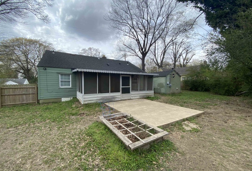 Back of property with a sunroom, a patio, a shingled roof, and a yard