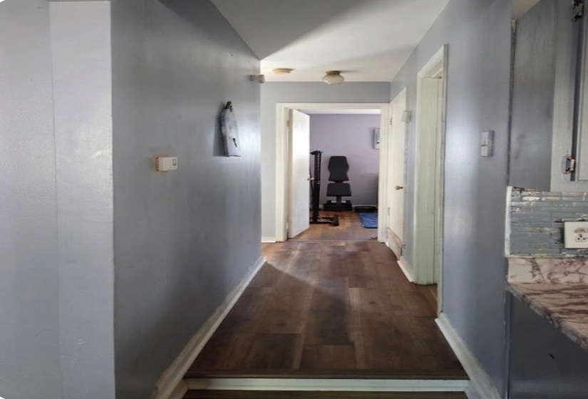 Hallway with dark wood-style floors and baseboards