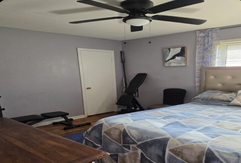Bedroom featuring ceiling fan and dark wood finished floors