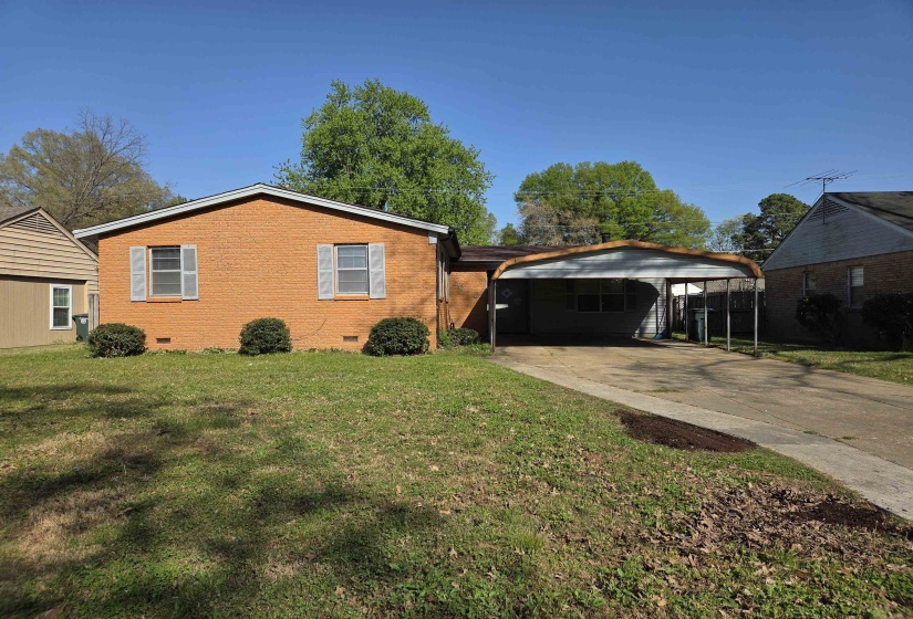 View of property exterior with crawl space, a yard, concrete driveway, brick siding, and an attached carport