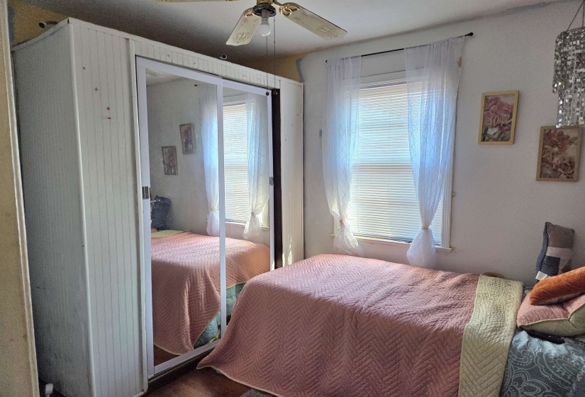 Bedroom with ceiling fan, a closet, and wood finished floors