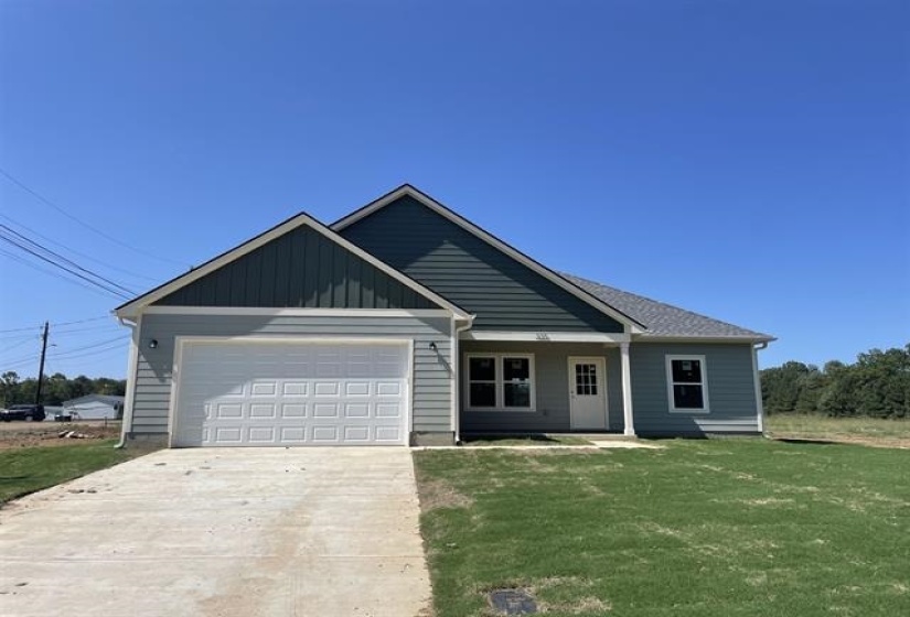 View of front facade with a garage and a front lawn