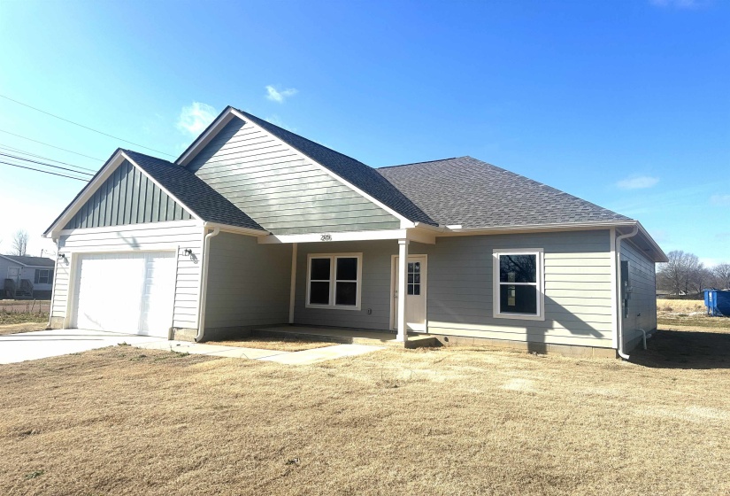 View of front of property featuring a garage and a front lawn