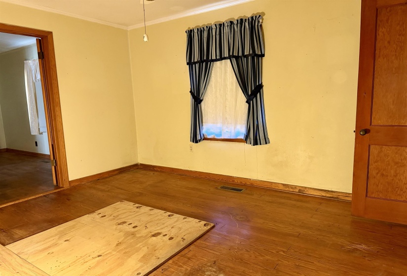Empty room featuring hardwood / wood-style floors and crown molding