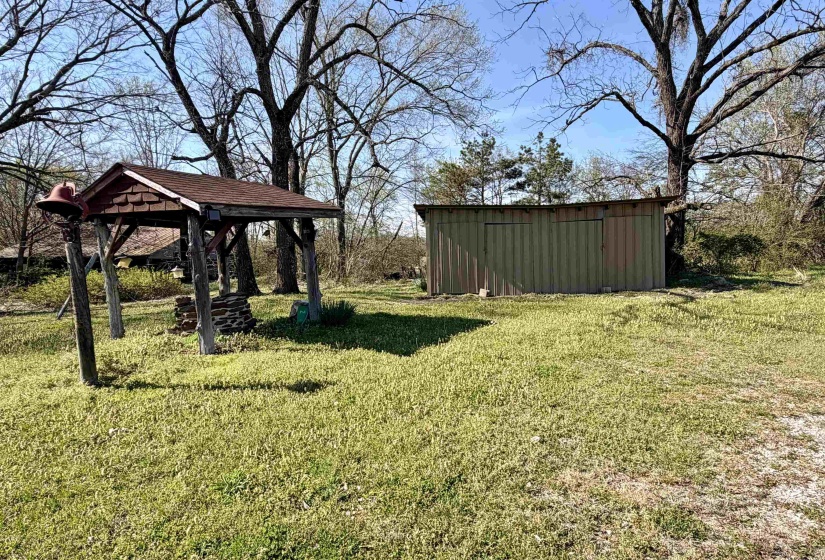 View of green lawn featuring a storage shed