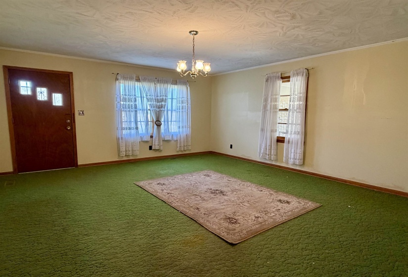 Unfurnished dining area featuring a chandelier, carpet floors, and ornamental molding