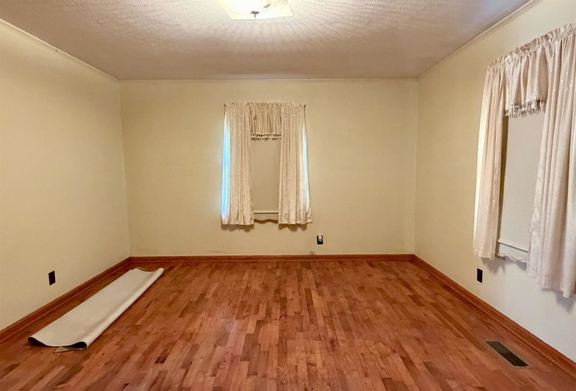 Empty room featuring wood finished floors and a textured ceiling