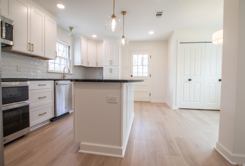 Kitchen with a healthy amount of sunlight, granite countertops, large island with overhang,  stainless steel appliances