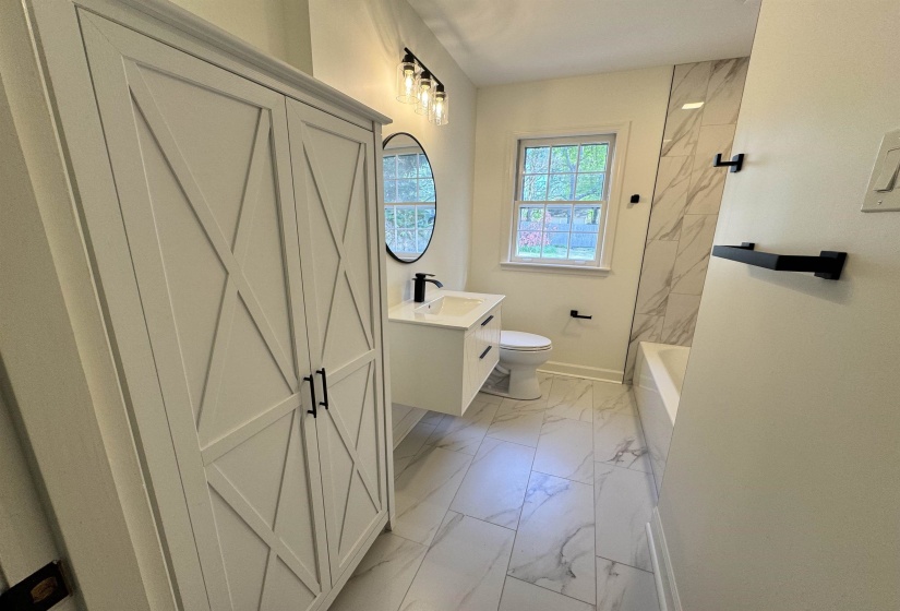 Bathroom featuring vanity, marble finish floor, baseboards, and toilet