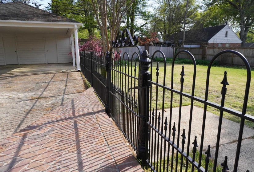 View of gate featuring fence and well maintained lawn