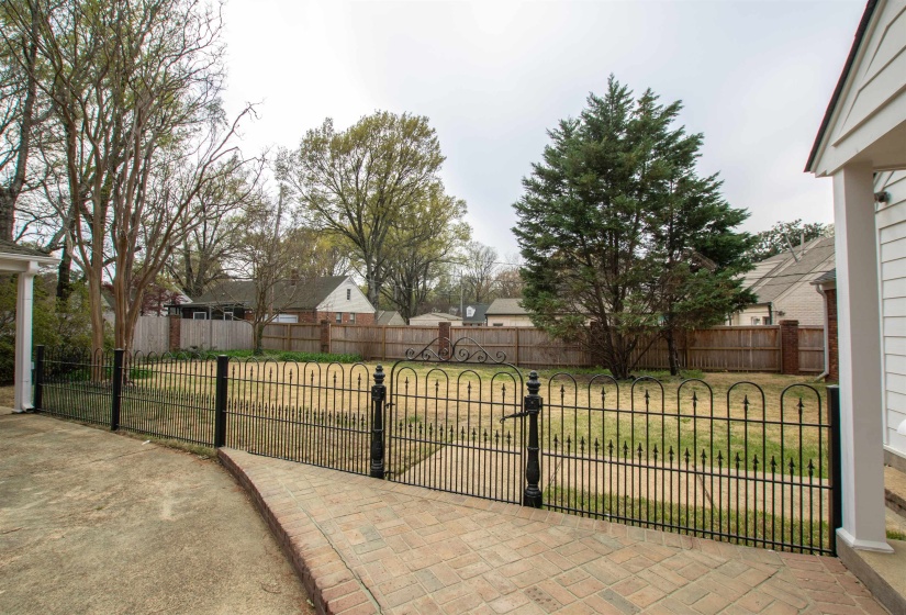 Exterior space with a gate and a fenced back yard