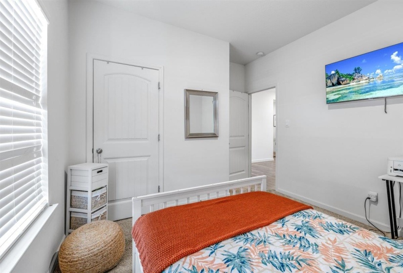 Carpeted bedroom featuring multiple windows