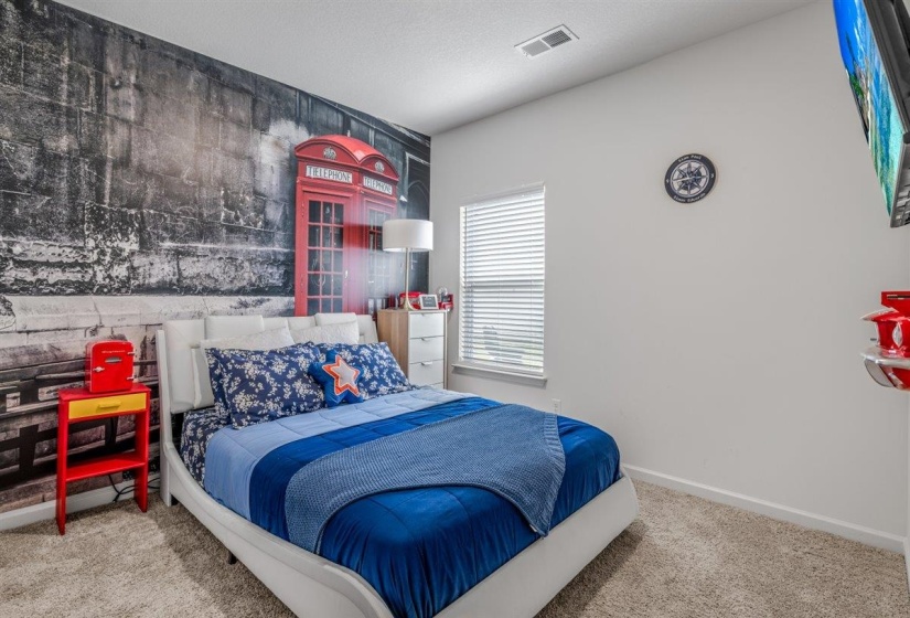 Bedroom featuring an accent wall and light colored carpet