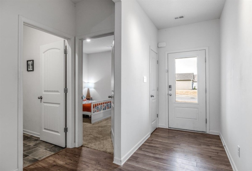 Foyer entrance featuring dark wood-type flooring and baseboards