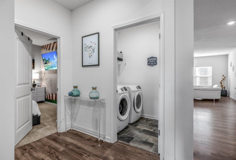 Laundry area with dark wood finished floors and washing machine and dryer