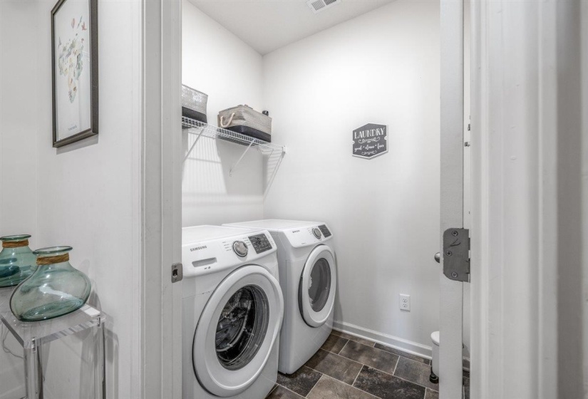 Laundry area with washer and clothes dryer and stone finish flooring