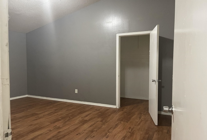 Additional living space with dark wood-style floors and a textured ceiling