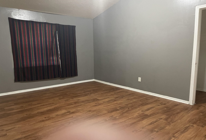Spare room with dark wood-type flooring and a textured ceiling