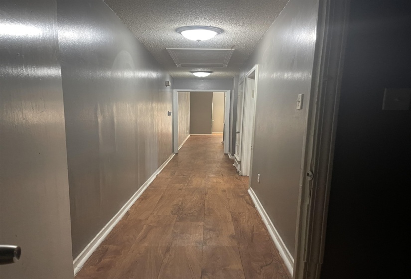 Hall featuring dark wood-style floors and a textured ceiling