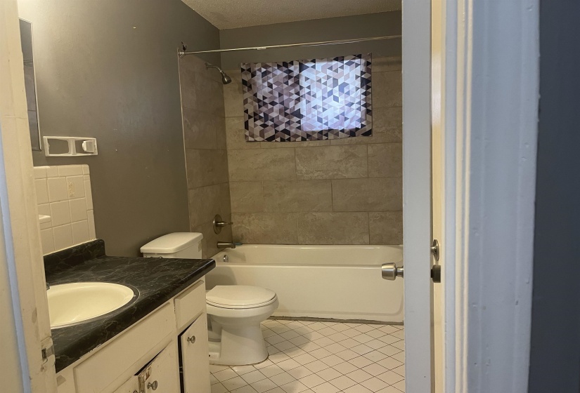 Full bathroom with vanity, washtub / shower combination, and light tile patterned floors