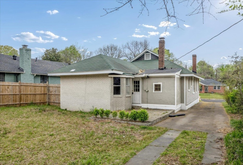 Rear view of house featuring a chimney and brick siding