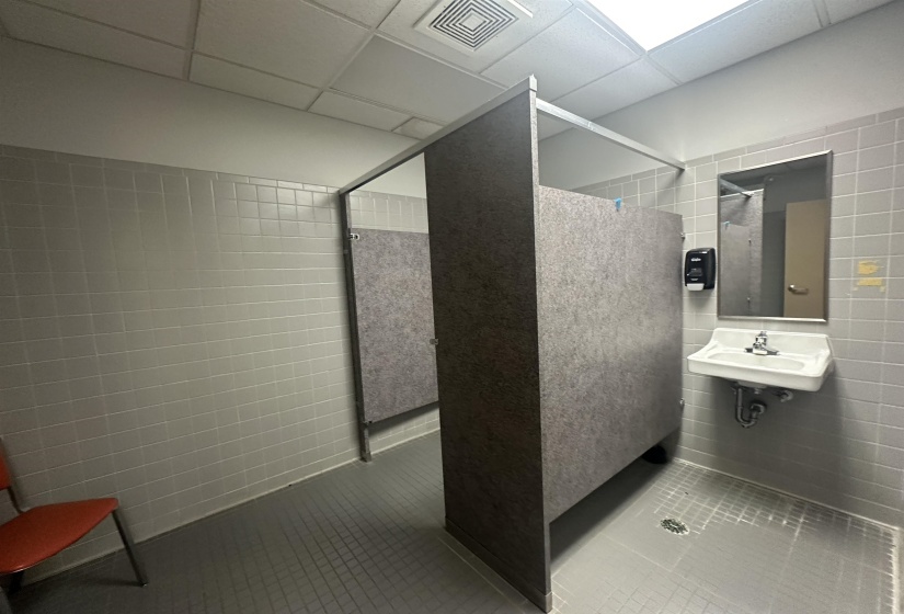 Bathroom featuring tile walls, visible vents, tile patterned flooring, a drop ceiling, and walk in shower