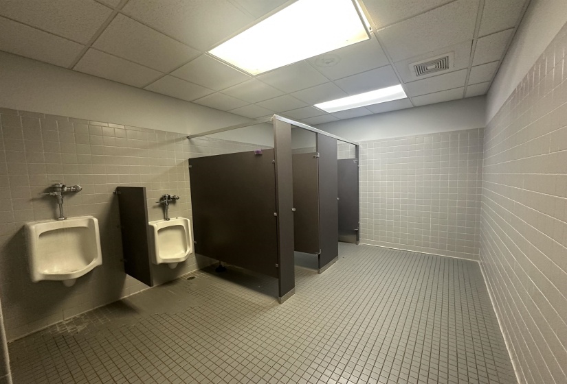 Full bath with tile walls, visible vents, a paneled ceiling, and a shower stall