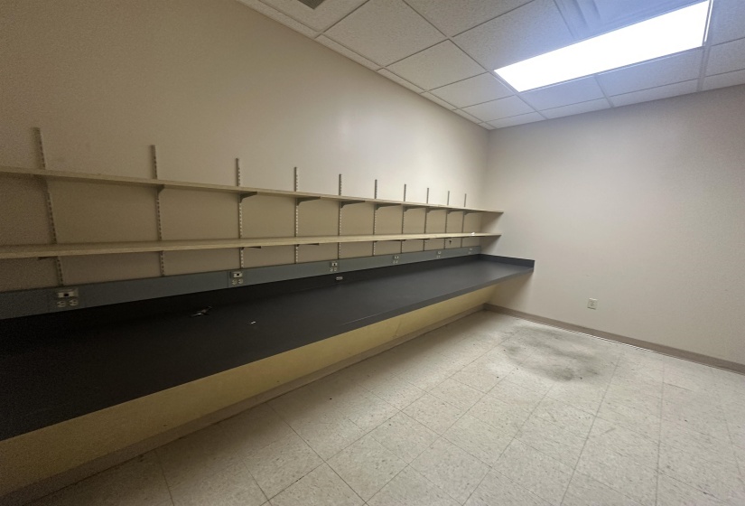 Interior space with a paneled ceiling, baseboards, and tile patterned floors