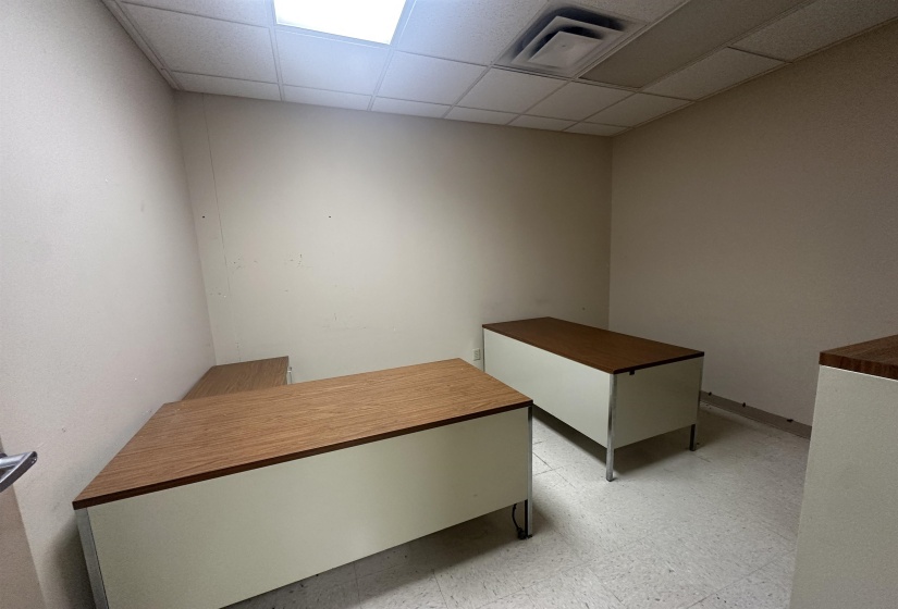 Unfurnished office with visible vents, light floors, and a paneled ceiling